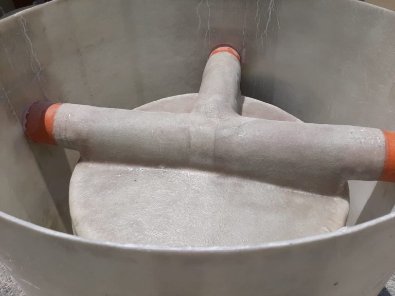 Laminated pipe channel inside a GRP manhole base